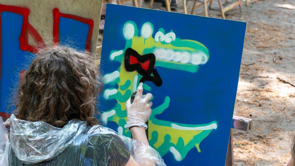Deelneemster ontwerpt krokodil met strik tijdens de Workshop Graffiti.