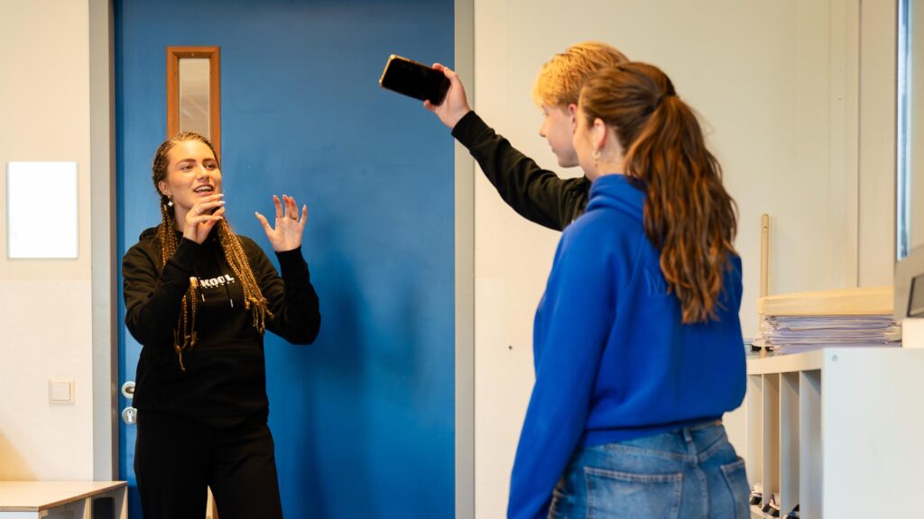 Twee deelnemers aan het vloggen onder begeleiding van de workshopdocent tijdens de Workshop Vloggen.