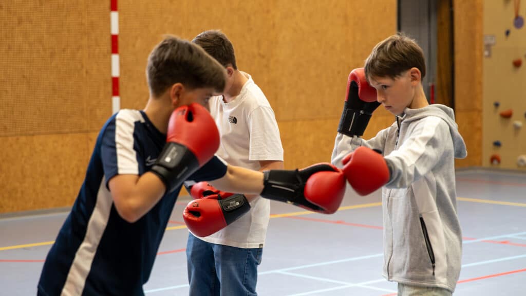 Deelnemers voeren oefeningen uit van de Workshop Kickboksen.