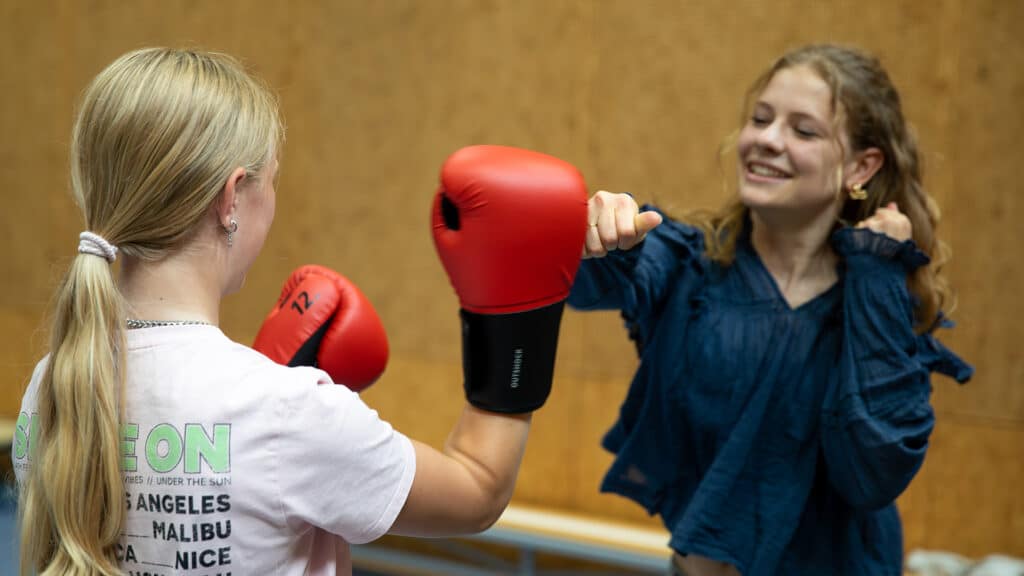 Twee deelnemers lachen tijdens het Kickboksen Kinderfeestje.