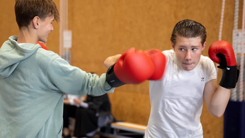 Deelnemer geeft een harde stoot tijdens de Workshop Kickboksen.