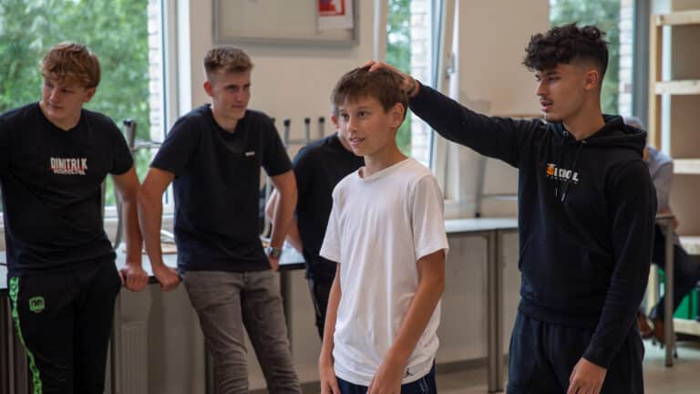 Workshopbegeleider doet een oefening voor met een deelnemer tijdens de Workshop Zelfverdediging.
