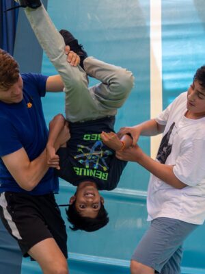 Deelnemer doet een salto onder begeleiding bij de Workshop Freerunning.