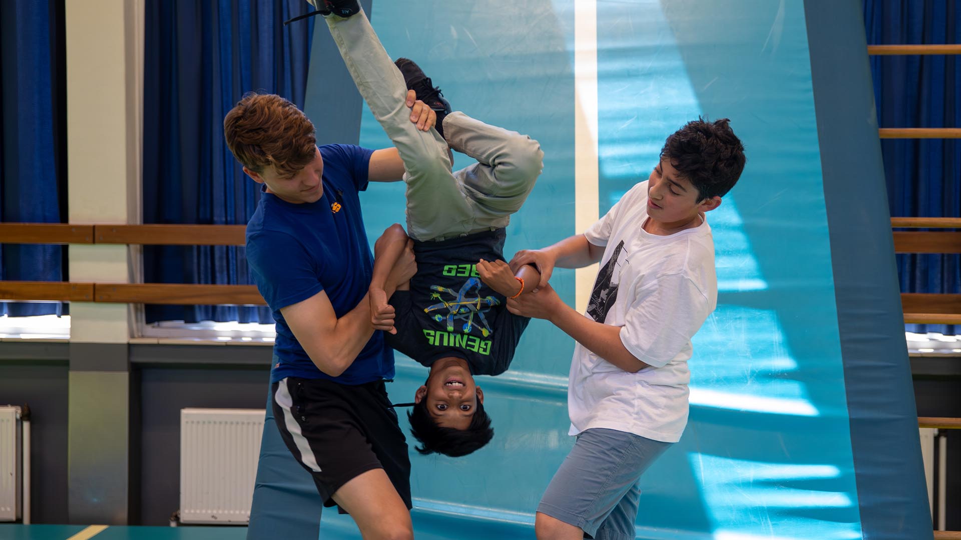 Deelnemer doet een salto onder begeleiding bij de Workshop Freerunning.