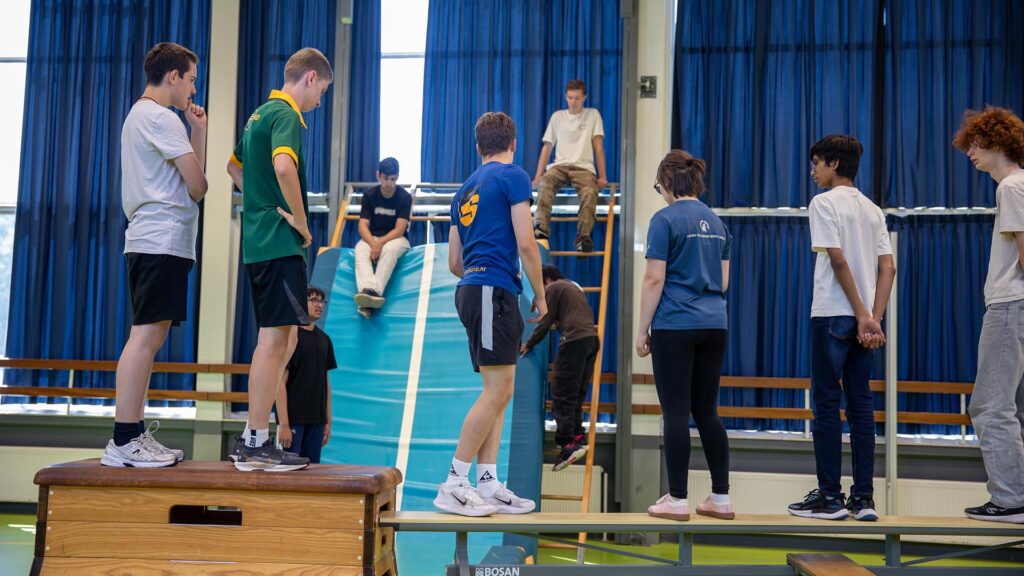 De deelnemers doen een warming-up onder begeleiding van de workshopdocent tijdens de Workshop Freerunning