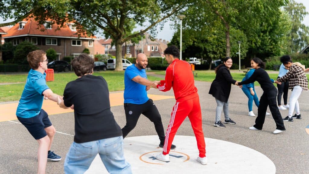 De workshopdocent doet een oefening voor samen met een deelnemer tijdens de Workshop Stage Fighting.