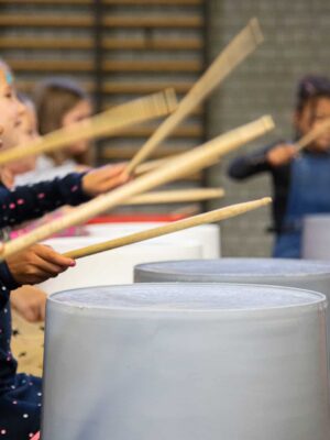 Groep leerlingen maakt samen ritme tijdens een muziekworkshop op school.