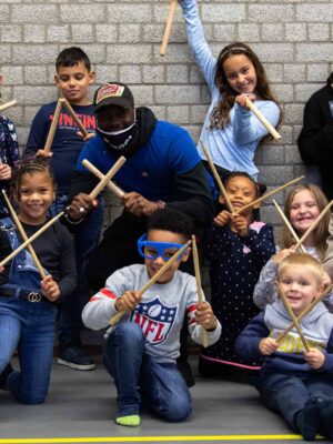 Leerlingen drummen samen op tonnen tijdens de Workshop Ghetto Drums.