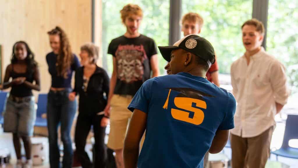 Enthousiaste warming-up door begeleider bij de Workshop Caribbean Drums