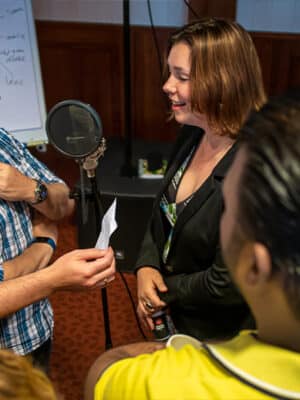 Deelnemer neemt een nummer op met een microfoon tijdens een muziekworkshop.