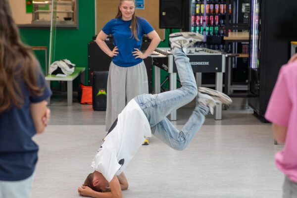 Deelnemer voert een oefening uit van de Workshop Breakdance.